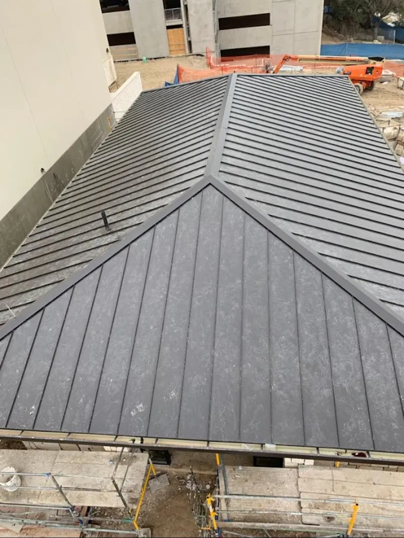 Commercial metal roof construction with crane equipment in Spring Valley